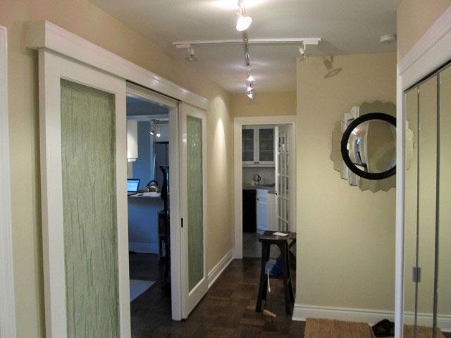 a hallway leading to a bedroom with a mirror on the wall